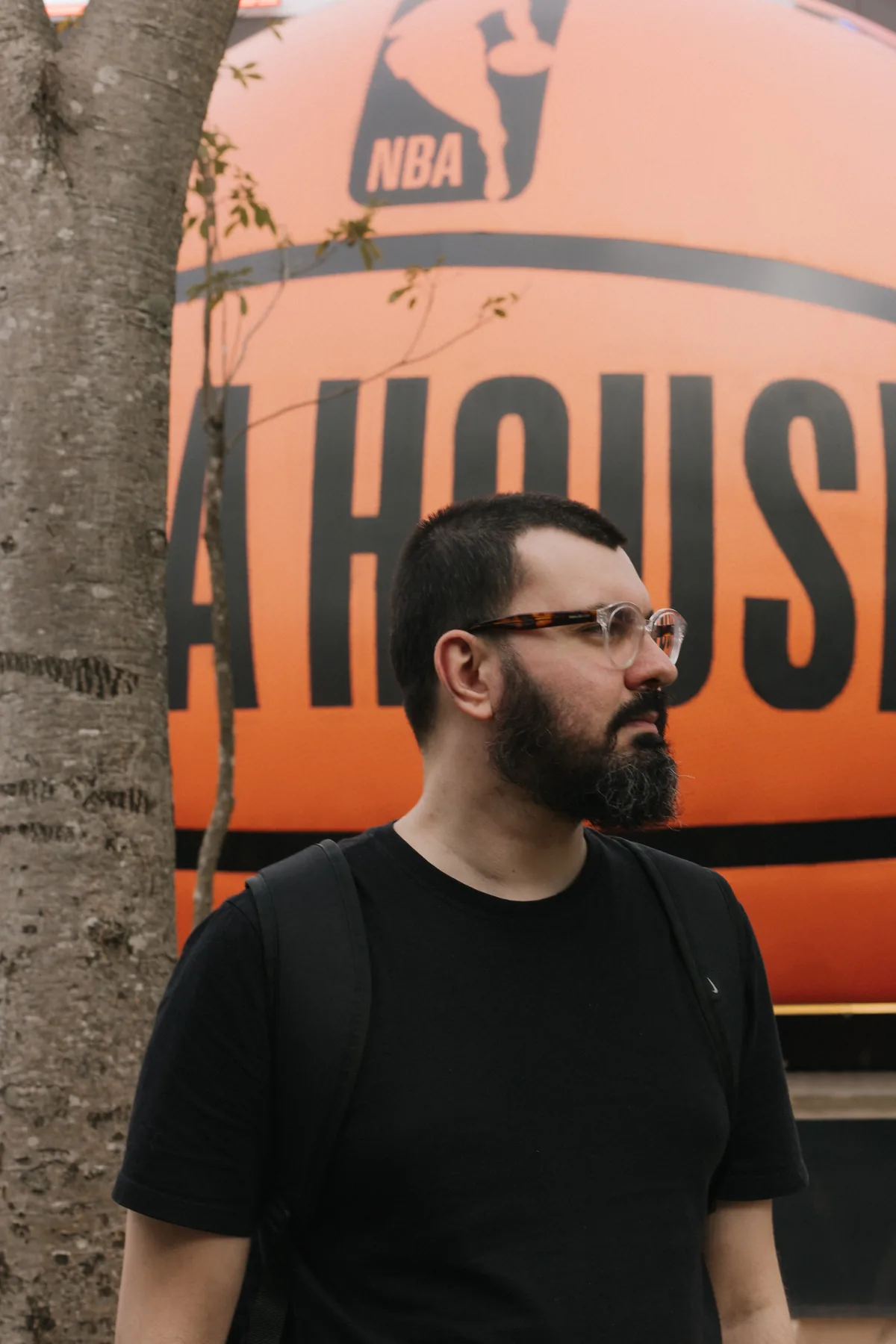 Raphael Vaz de perfil, em frente a um balão gigante de basquete da NBA House